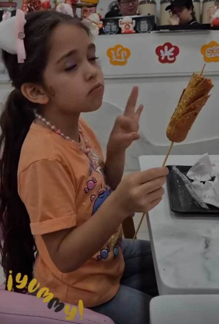 Una clienta con su corn dog en Hi Tea